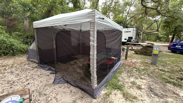 Gray canopy tent set up at camp