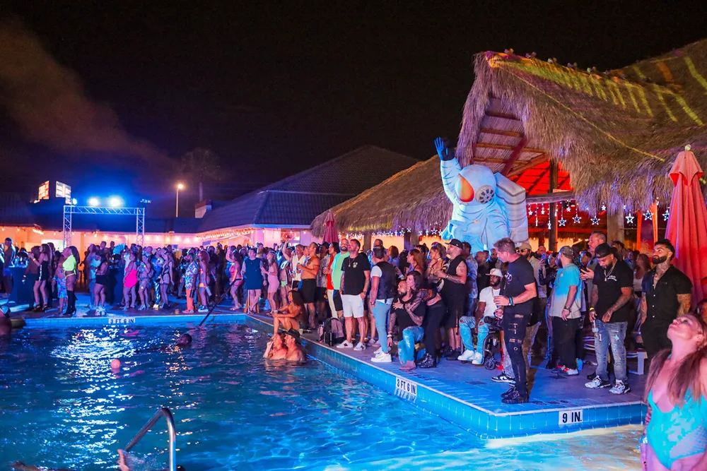 A night pool party by the tiki bar at Secrets Hideaway